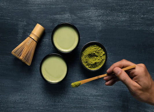 A person putting matcha powder in the cup